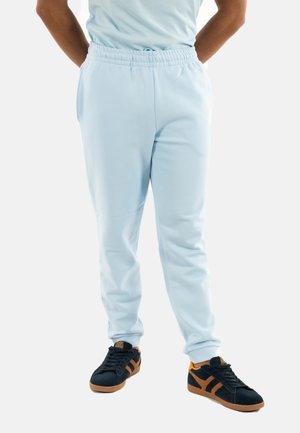 Lichtblauwe joggingbroek van zachte stof met een elastische tailleband. Te combineren met zwarte sneakers met oranje accenten en gumrubberen zolen.