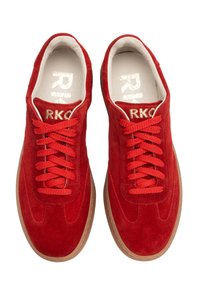 Czerwone zamszowe sneakersy z teksturowaną powierzchnią, z płaskimi czerwonymi sznurowadłami i gumową podeszwą. Wnętrze ma białą podszewkę i logo.