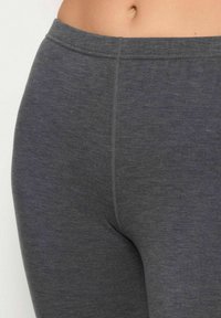 Szare legginsy wykonane z miękkiego, elastycznego materiału. Posiadają wysoki pas i gładkie detalowanie szwów. Zapewniają komfort i elastyczność.