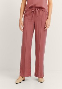 Lässig geschnittene, hoch taillierte Hose aus einem weichen Mauve-Stoff mit einem Bindeband an der Taille. Merkmale sind gerade Beine und eine glatte Textur.