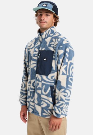 Fleece jacket with blue and white abstract pattern, full zip, high collar, navy front pocket, soft texture, and relaxed fit.