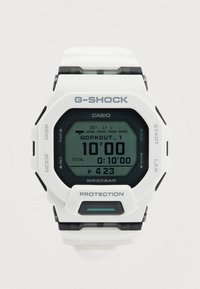 Weiße digitale G-SHOCK-Uhr mit sechseckigem Design, schwarzen Akzenten, grünem Hintergrundlicht und Anzeige des Trainingszählers. Wasserdicht bis 20 bar.