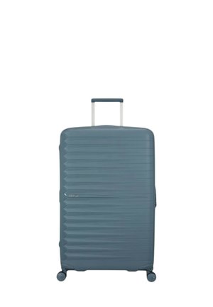 Hard-shell suitcase in muted blue, featuring a diagonal ribbed texture, retractable handle, and four spinner wheels for easy maneuverability.