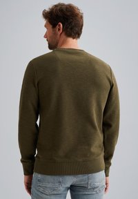 Sudadera de cuello redondo verde oliva con puños y dobladillo acanalados, que presenta una tela texturizada y un ajuste relajado, mostrada desde la parte posterior.