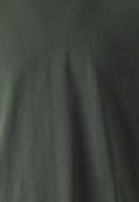Dunkelgrünes T-Shirt aus weichem Stoff mit glatter Textur. Einfaches Design ohne sichtbare Muster oder Akzente.