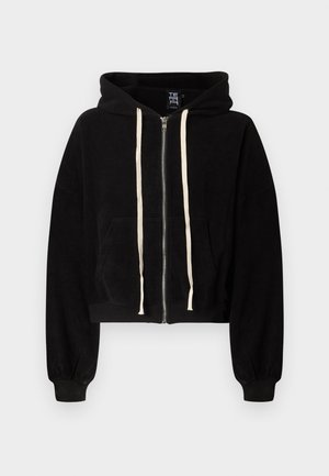 Μαύρο φούτερ με φερμουάρ, λευκά κορδόνια, μπροστινές τσέπες και ριμπ μανσέτες, εμφανισμένο σε ανοιχτό γκρι φόντο.