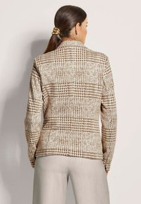 Bruin en crème geruit blazer met een gestructureerd ontwerp en lange mouwen. Voorzien van een kraag en een gladde geweven textuur.