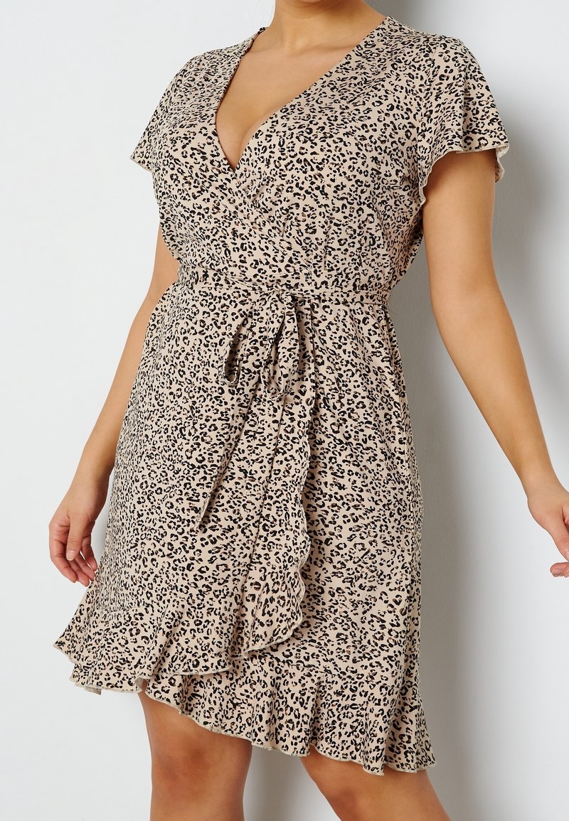 Beige šaty s leopardím vzorem, s krátkými volánkovými rukávy, zavazovacími boky a rozšířeným lemem s volánkovým detailem.