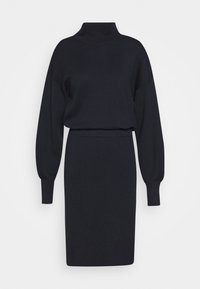 Robe en tricot bleu marine foncé avec un col montant, des manches longues bouffantes et une silhouette ajustée se terminant au niveau du genou. Texture douce.