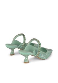 Chaussures à talons vert menthe ornées de strass brillants, à bout pointu, et avec une bride décorative agrémentée d'accents carrés sur le talon.