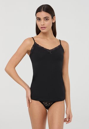 Top in raso nero con spalline regolabili, rifiniti in pizzo lungo il colletto e dal design aderente. Abbinato a culotte in pizzo nero.
