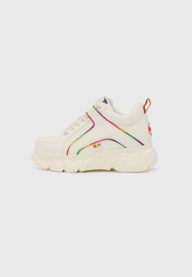 Zapatilla blanca con acentos y cordones multicolores. Presenta una suela gruesa y paneles laterales texturizados con un diseño de raya arcoíris.