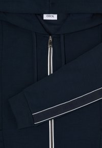 Marineblauer Kapuzenpullover mit Reißverschluss und weißem Reißverschluss, weiche Textur, mit einem markierten Bündchen mit kontrastierendem Streifendesign.