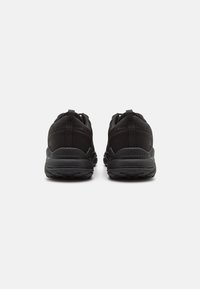 Black athletic shoes with a smooth fabric upper, cushioned sole, and reinforced heel. Features pull tabs on the back for easy wear.