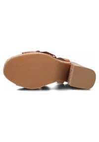 Tan geklede sandaal met een gestructureerde rubberen zool. De hak is blokvormig en de binnenzool heeft een kurken patroon.