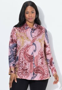 Langärmliges Hemd mit Knopfleiste aus pinkfarbigem Stoff mit einem Paisleymuster in Rot, Marineblau und gelben Akzenten. Glatte Textur, klassischer Kragen.