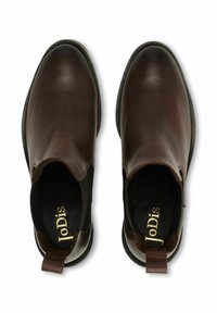 Smeđe kožne gležnjače glatke završne obrade, s elastičnim bočnim panelima i trakicom za povlačenje straga. Imaju izdržljiv crni gumeni potplat.