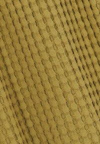 Tissu texturé en vert olive avec un motif en grille, présentant des tissages ouverts et des détails en tricot, créant un effet visuel superposé.