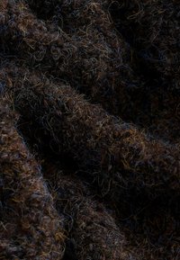 Bruine textuurstof met een vlezige uitstraling, waarbij fijne strengen blauwe en gouden draden door elkaar zijn geweven.