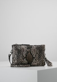 Borsa a tracolla con motivo pitone in grigio e nero, dotata di chiusura con zip, tracolla rimovibile e dettaglio decorativo con nappina.