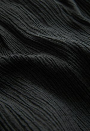 Tissu noir texturé avec des nervures verticales proéminentes, présentant un aspect légèrement froissé et une finition douce et mate.