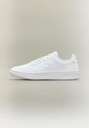 Weißer Low-Top-Sneaker mit Schnürung vorne, geprägt mit Krokodillogo an der Seite und strukturierter Sohle auf neutralem Hintergrund.