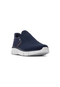 Zapatilla azul de punto sin cordones con parte superior texturizada, entresuela blanca y una franja de acento. Diseño ligero adecuado para uso casual.