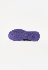 Sko sål med en struktureret lilla gummioverflade med zigzag-mønstre og et logo i midten. Flad, rund form med grebdesign.
