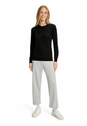 Black long-sleeve sweater paired with light gray wide-leg pants and white sneakers. The fabric appears smooth and soft.