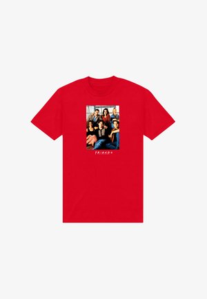 Červené tričko s fotografií skupiny šesti usmívajících se lidí, kteří sedí a stojí spolu, s nápisem "FRIENDS" pod obrázkem.