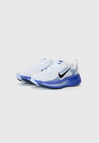 Pantofi sport albi cu accente albastre, superior din plasă și logo Swoosh negru. Prezintă o talpă căptușită pentru confort și aderență.