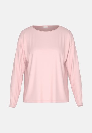 Lichtroze top met lange mouwen gemaakt van zachte stof. Heeft een ronde hals, doorgezakte schouders, een losse pasvorm en minimale naden.