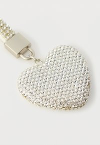 Silver heart-shaped pendant adorned with small, sparkling crystals. Attached to a textured metallic strap with a sturdy clasp.