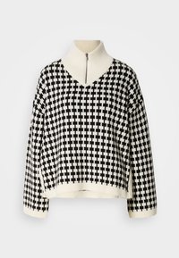 Maglione in nero e crema con un motivo a scacchi, dotato di un collarino alto e una mezza cerniera. Realizzato in un materiale a maglia testurizzata.
