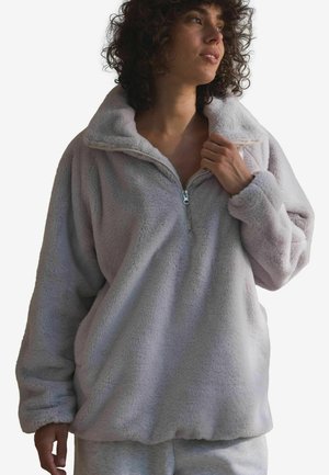Lys grå pullover lavet af blødt fleece, med krave med halv lynlås og lange ærmer, i en afslappet pasform og med en luksuriøs tekstur.