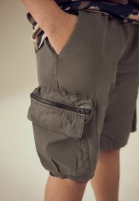 Shorts cargo kaki avec une finition texturée, dotés d'une poche latérale zippée et d'une taille élastique pour le confort.