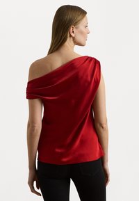 Röd satin off-shoulder topp med draperat tyg och en slät yta. Har en avslappnad passform och minimala sömnadsdetaljer.