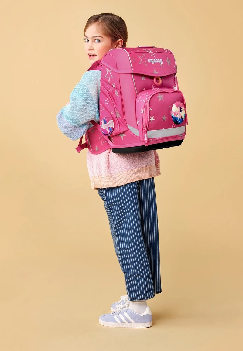 Zaino rosa con motivi a stelle argento, tasche frontali doppie e dettagli riflettenti. Spallacci e base imbottiti per comfort e durata.