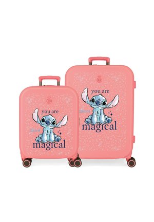 Dos maletas rosas con el personaje de dibujos animados Stitch y el texto "you are magical" en la parte frontal, ambas con cuatro ruedas negras y rosas.
