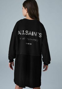 Juodas per didelis megztinis su metaliniu "ALLSAINTS" tekstu ir klostuota sijonu. Medžiaga atrodo minkšta, su raštuotais rankogaliais ir apatine dalimi.