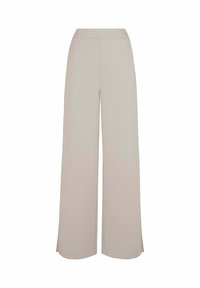 Lichtbeige wijde broek met een elastische tailleband, zachte textuur en openingen aan de onderkant voor extra bewegingsvrijheid. Casual en comfortabele uitstraling.