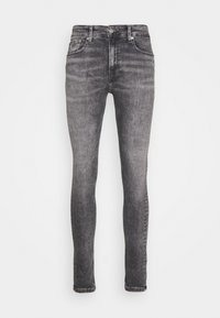 Jeans ajustados en denim gris con un lavado desgastado, que cuentan con cinco bolsillos, un cierre frontal de botón y cremallera, y detalles de costura mínimos.