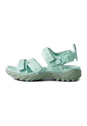 Light green outdoor sandal with three adjustable straps, thick textured sole, and pull tab at heel, shown from the side on white background.