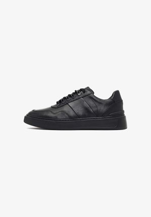 Zwarte leren sneakers met een gladde afwerking, ronde neus, gestructureerde zijstrepen, zwarte veters en een dikke zwarte rubberen zool.