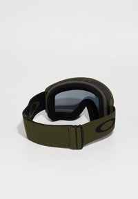 Gröna skidglasögon med mörkt glas, vadderad skumisolering och justerbar rem. Har en framträdande varumärkeslogotyp på remmen.