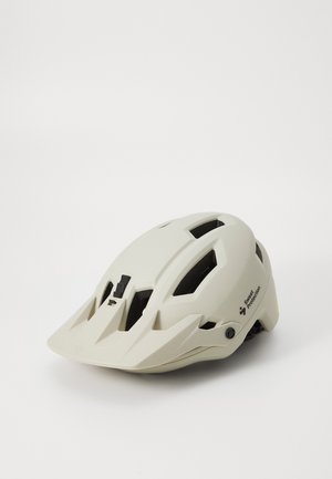 Šviesiai smėlio spalvos kalnų dviračio šalmas su juodais akcentais, ventiliacijos skylėmis ir reguliuojama tvirtinimo sistema. Yra skydelis saulės apsaugai.