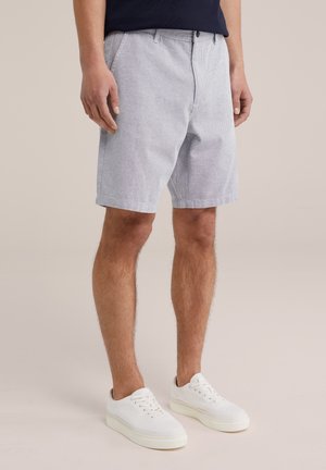 Grårandiga shorts i ett lätt tyg, platt framdesign och sidofickor, kombinerat med vita sneakers på en neutral bakgrund.