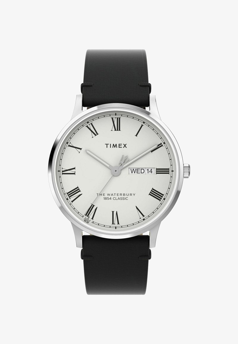 Het Timex Waterbury horloge heeft een ronde kast van zilverkleurig roestvrij staal, een witte wijzerplaat met Romeinse cijfers, een zwarte leren band en een datumaanduiding.
