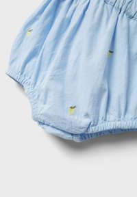 Mono de algodón azul claro con puños elásticos y motivos de hojas bordados en amarillo y verde. Textura suave y diseño gather.