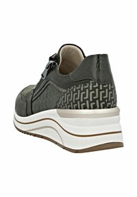 Zapatilla negra y gris con talón estampado, cremallera lateral, suela blanca acolchada con franjas beige y marrón, vista angular desde la parte trasera derecha.